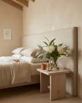 Cream pincushion and eucalyptus in a Sphere glass vase on a bedside table in a Bondi beach house.