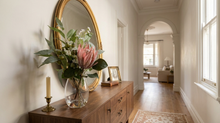 King protea with native pincushion and eucalyptus in a Claire glass vase, on a Paddington terrace entry console.