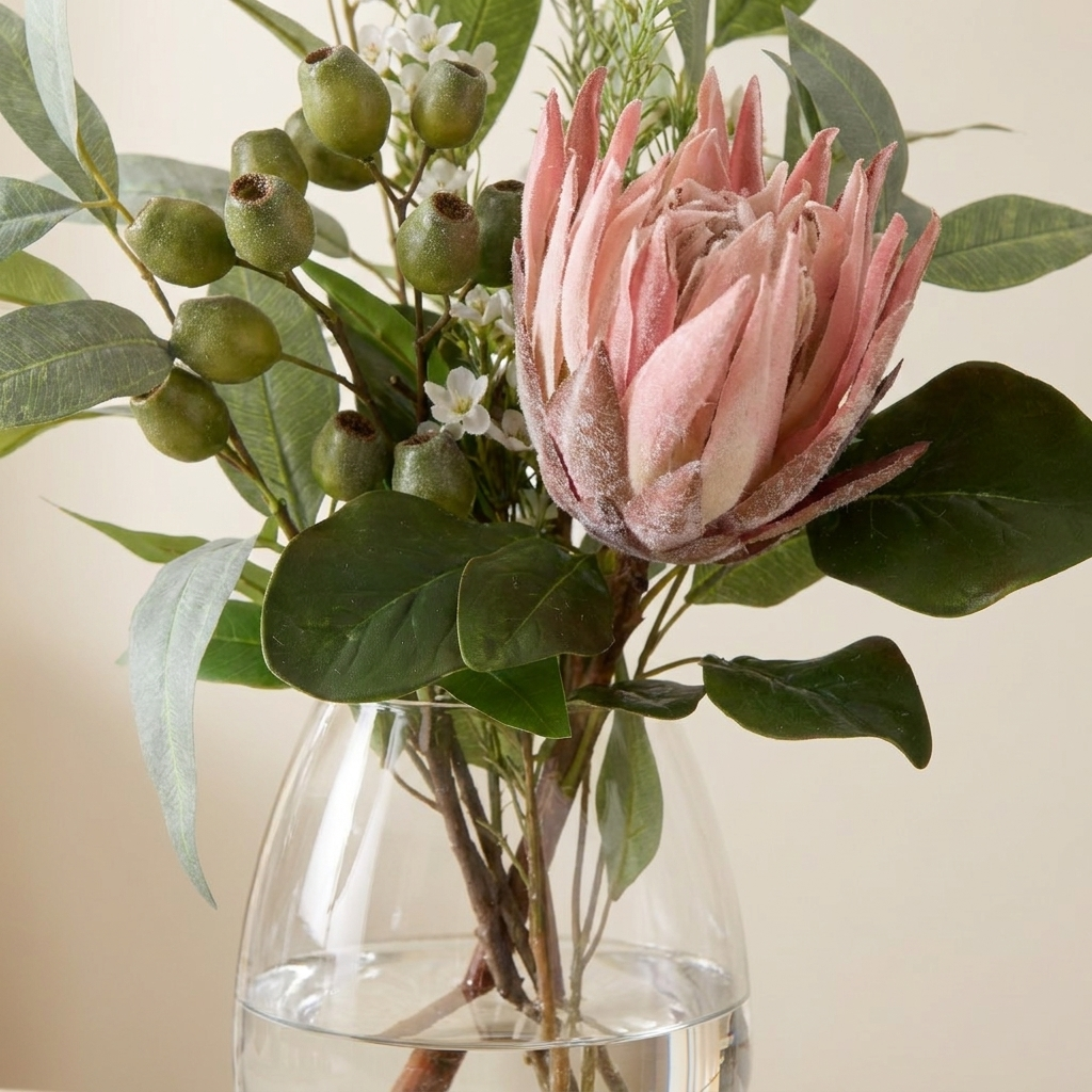 Close-up of the flocked king protea petal, gumnuts and eucalyptus foliage in the Claire glass vase.